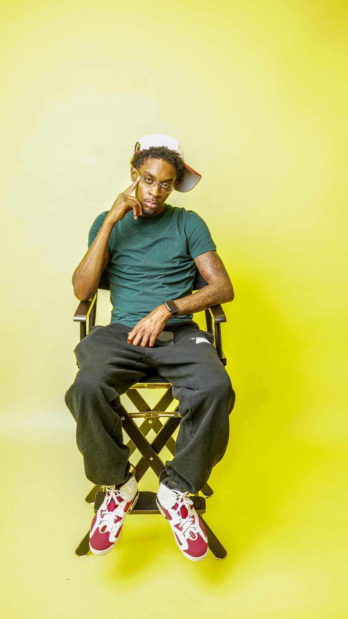 Bobby Starr posed in a director's chair on a yellow backdrop